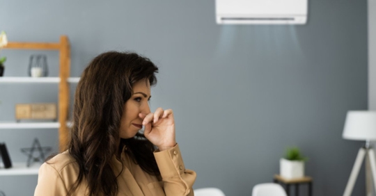 woman turning up her nose at AC smell